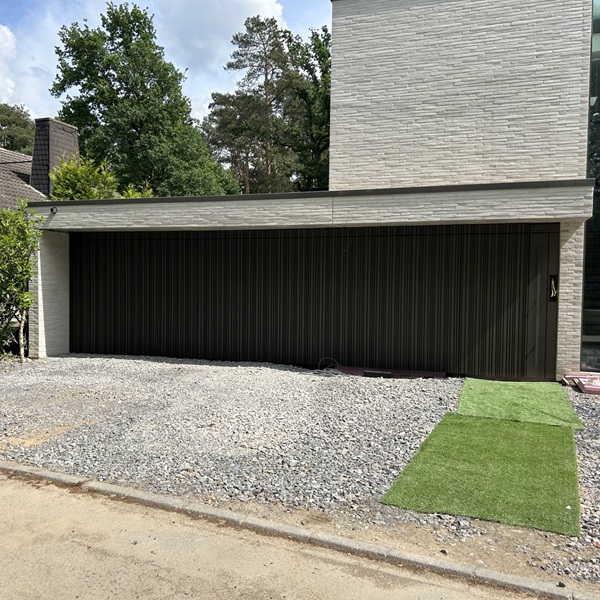 Vorgehängte hinterlüftete Fassade mit flächenbündigem Garagentor als Rohrfassade an einem Einfamilienhaus