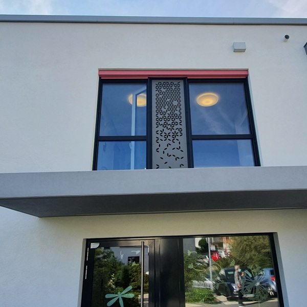 Vorgehängte hinterlüftete Fassade aus HPL mit Fräsungen an einem MFH